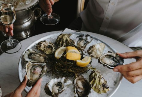 Two People Enjoying Oysters and Wine