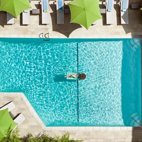 Aerial view of a guest relaxing in the Sunset Marquis pool